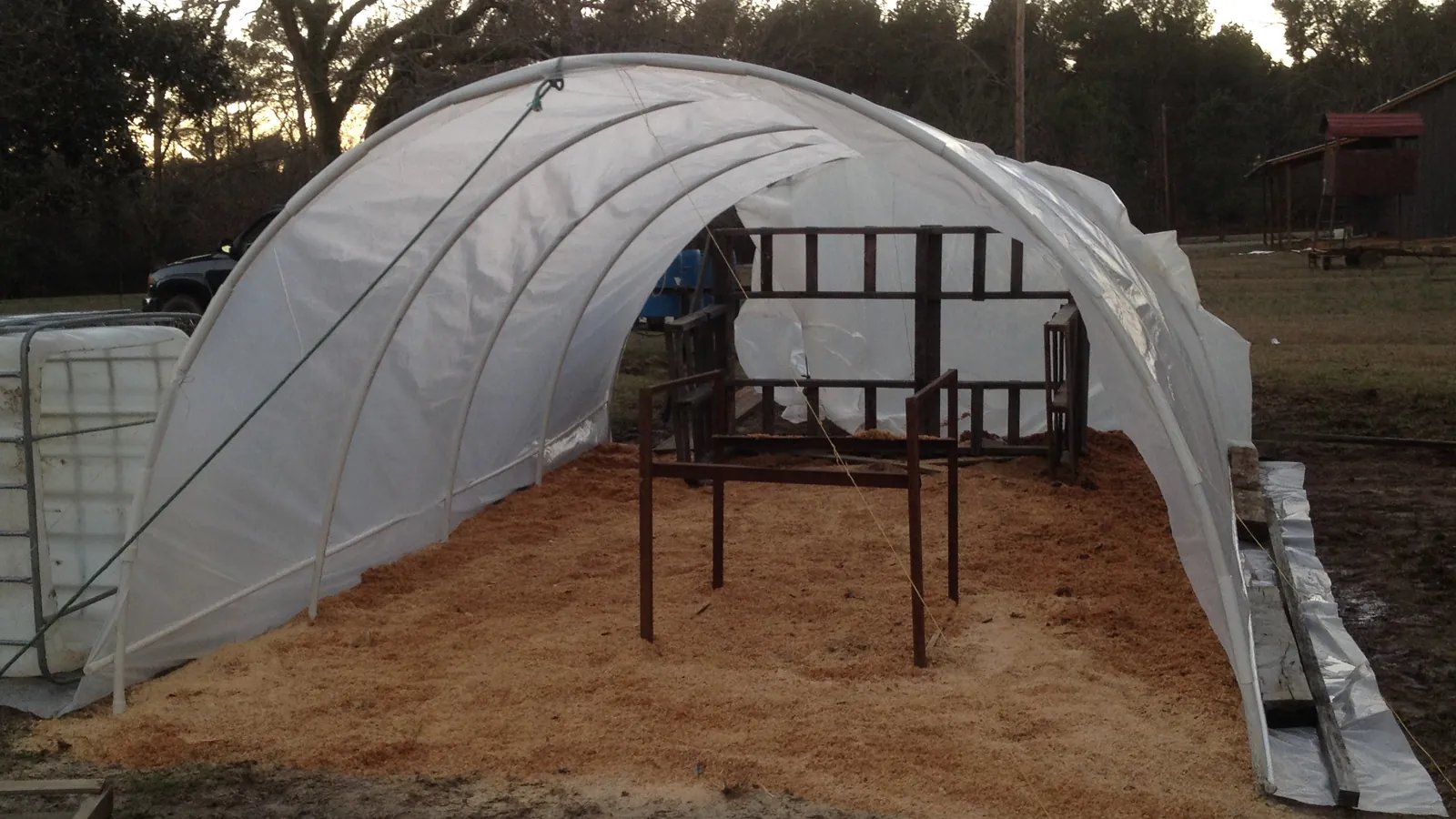 Open hoop house with sawdust floor and potting frame